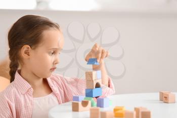 Little girl with autistic disorder playing with blocks at home�