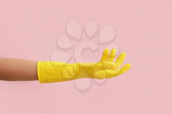 Hand in rubber glove on color background�