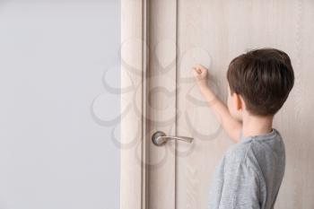 Little boy knocking at closed door�