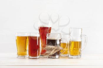 Glasses of different fresh beer on light background�
