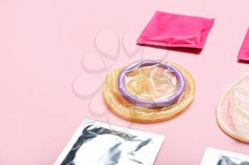 Wrapped and open condoms on color background�