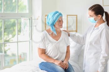 Doctor telling good news to mature woman after chemotherapy in clinic�