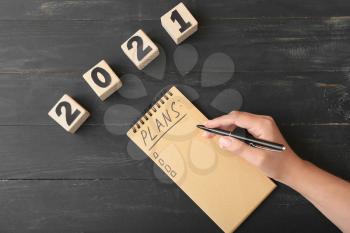 Woman making to-do list on 2021 year at table�