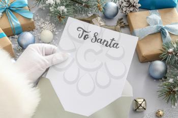 Santa Claus reading letter at table�