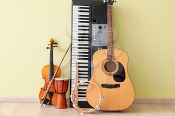 Different musical instruments near color wall�