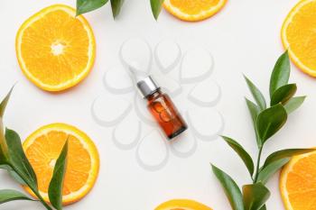 Composition with bottle of orange essential oil on white background�