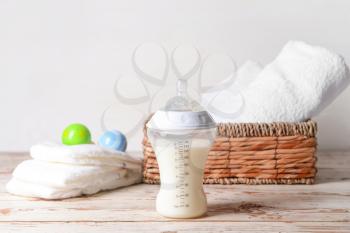 Bottle of milk for baby with accessories on table�
