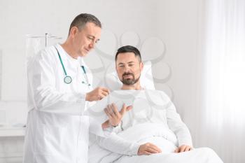 Doctor and man undergoing course of chemotherapy in clinic. Prostate cancer awareness concept�