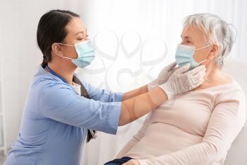 Doctor examining senior woman in clinic�