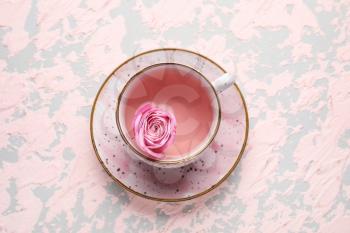 Cup of tea with rose on color background�
