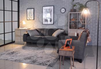 Interior of stylish living room with sofa and armchair�