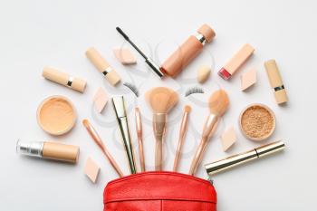 Decorative cosmetics and makeup brushes on light background�