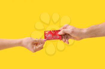 Hands with gift card on color background�