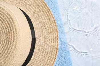 Stylish hat and towel on light background with water splashes, closeup�