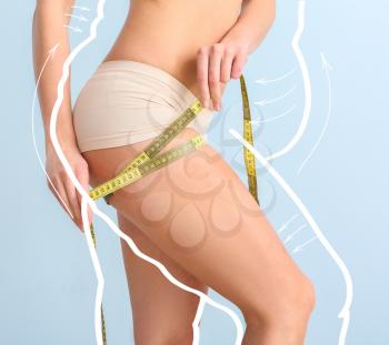 Young woman with measuring tape after weight loss on color background�