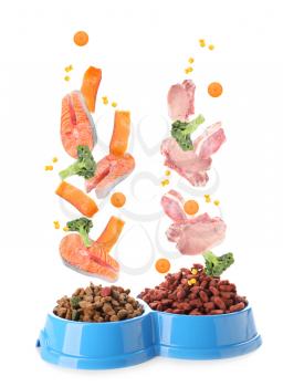Different pet food falling into bowls against white background�