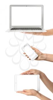 Hands with laptop, tablet computer and mobile phone on white background�