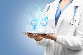 Female gynecologist with tablet computer on color background. Concept of sexual health�