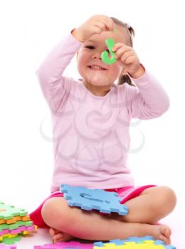 Royalty Free Photo of a Little Girl Holding a Piece of an Alphabet Puzzle