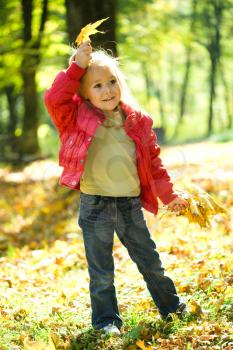 Royalty Free Photo of a Little Girl Playing in Autumn Leaves