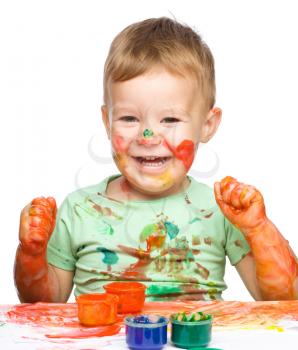 Child is grabbing some paint using fingers, isolated over white
