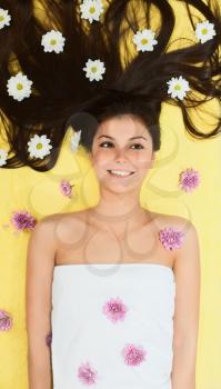 Royalty Free Photo of a Girl Lying Down With Daisies on Her