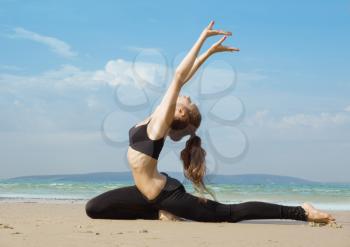 Young girl making exercise on the beach.
