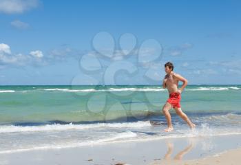 a young man running along the coast