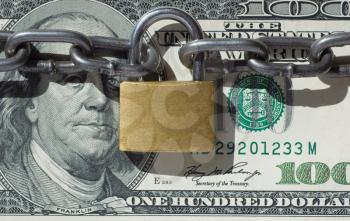 Financial security concept image
one hundred dollars locked  with padlock