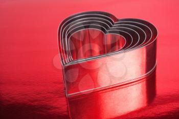 Some of the metal hearts shaped over red background.Shallow DOF 