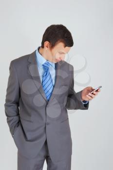 Young businessman with mobile phone and his hand in the pocket