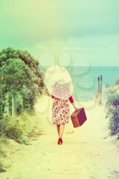 beautiful lady in red traveler in retro style   on the beach