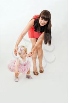 Beautiful happy mother with baby daughter on white background 
