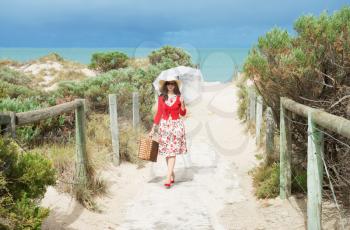 beautiful lady traveler in red  and  retro style  on the beach
