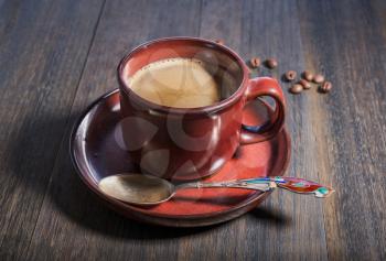 Coffee cup and beans on grunge oak wooden background