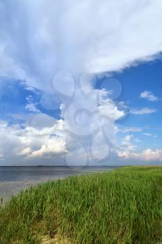 Royalty Free Photo of Blue Sky and Grass By a Bay