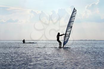 Silhouette of a windsurfer on the water surface