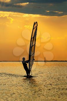 Man windsurfer on the sea bay surface