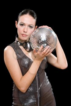 Portrait of beautiful young brunette with a mirror ball in her hands. Isolated on black
