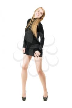 Young smiling blond woman in short black dress showing her nice legs. Isolated on white
