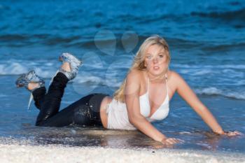 Attractive young blond woman posing on the beach