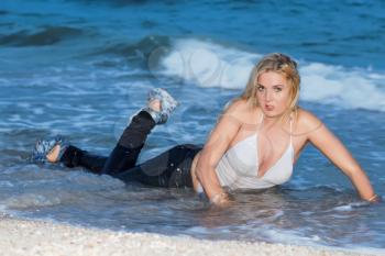 Charming young blond woman lying in the water