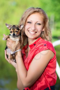 Cheerful blond woman posing with a small dog