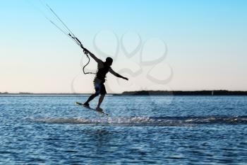 Silhouette of a kitesurfer jumping over the water