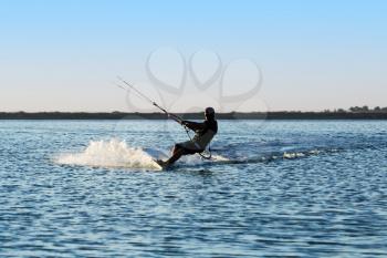 Silhouette of a kitesurfer sailing in the sea