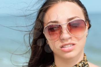 Portrait of young pretty brunette wearing brown sunglasses