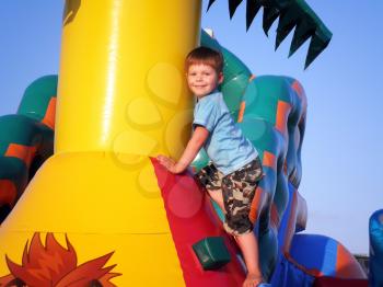 Royalty Free Photo of a Boy Playing on an Inflatable Castle