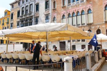 VENICE, ITALY - MAY 06, 2014: Waiters serve tables in outdoor restaurant in Venice, Italy