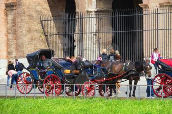 ROME, ITALY - MAY 04, 2014: Coachmen sitting on chairs, pulled by a horse, waiting for tourists to the area near the Colosseum in Rome, Italy