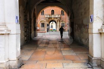 VERONA, ITALY - MAY 7, 2014: Pedestrian under the arch at Piazza della Signoria in Verona, Italy